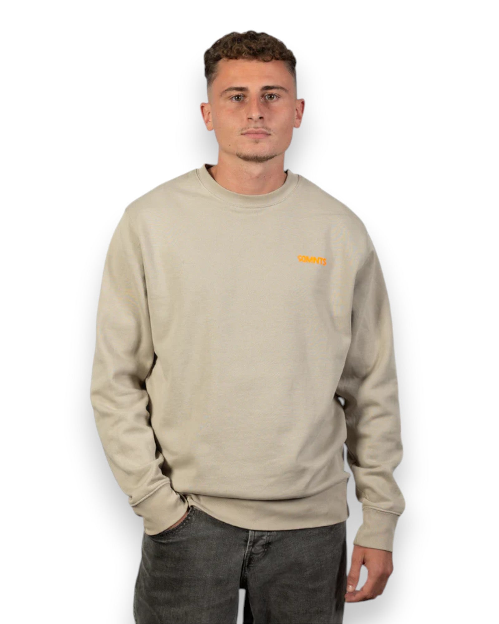 Männliches Model trägt BE PART OF THE GAME Sweater in Stone mit orangene Print