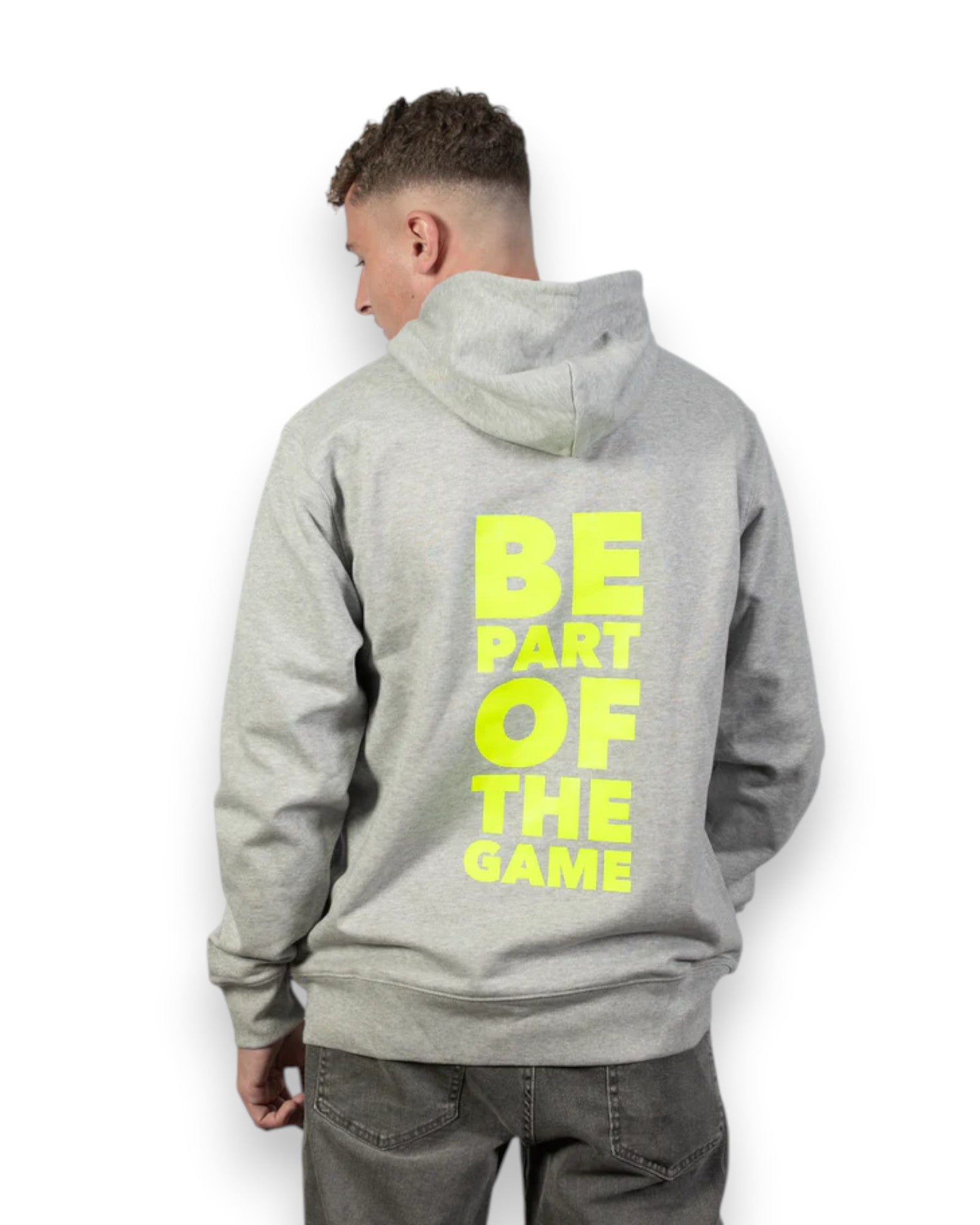 Männliches Model trägt BE PART OF THE GAME Hoodie in Grau mit Print in Gelb