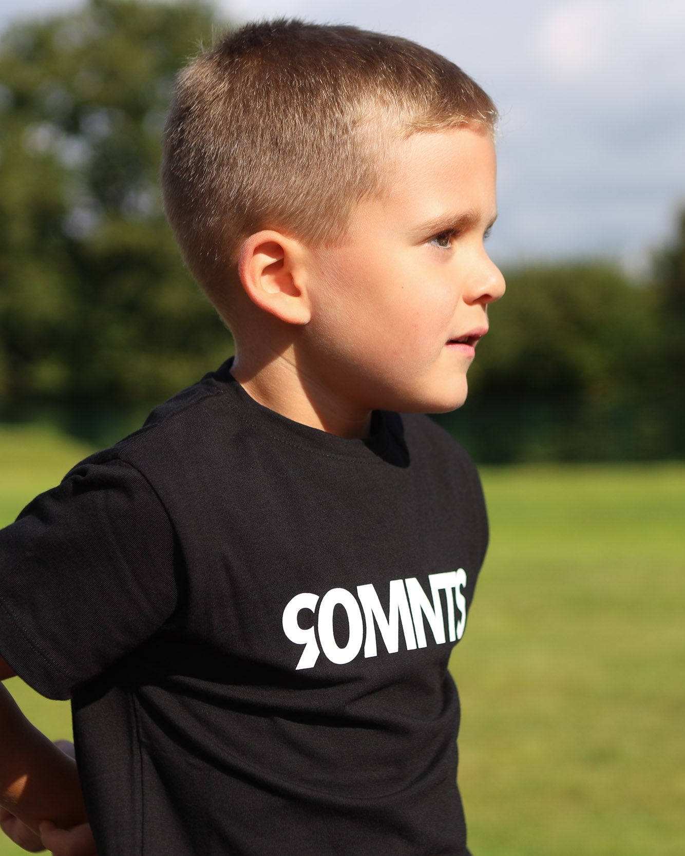 Kind trägt 90 Core T-Shirt in schwarz mit weißem Print