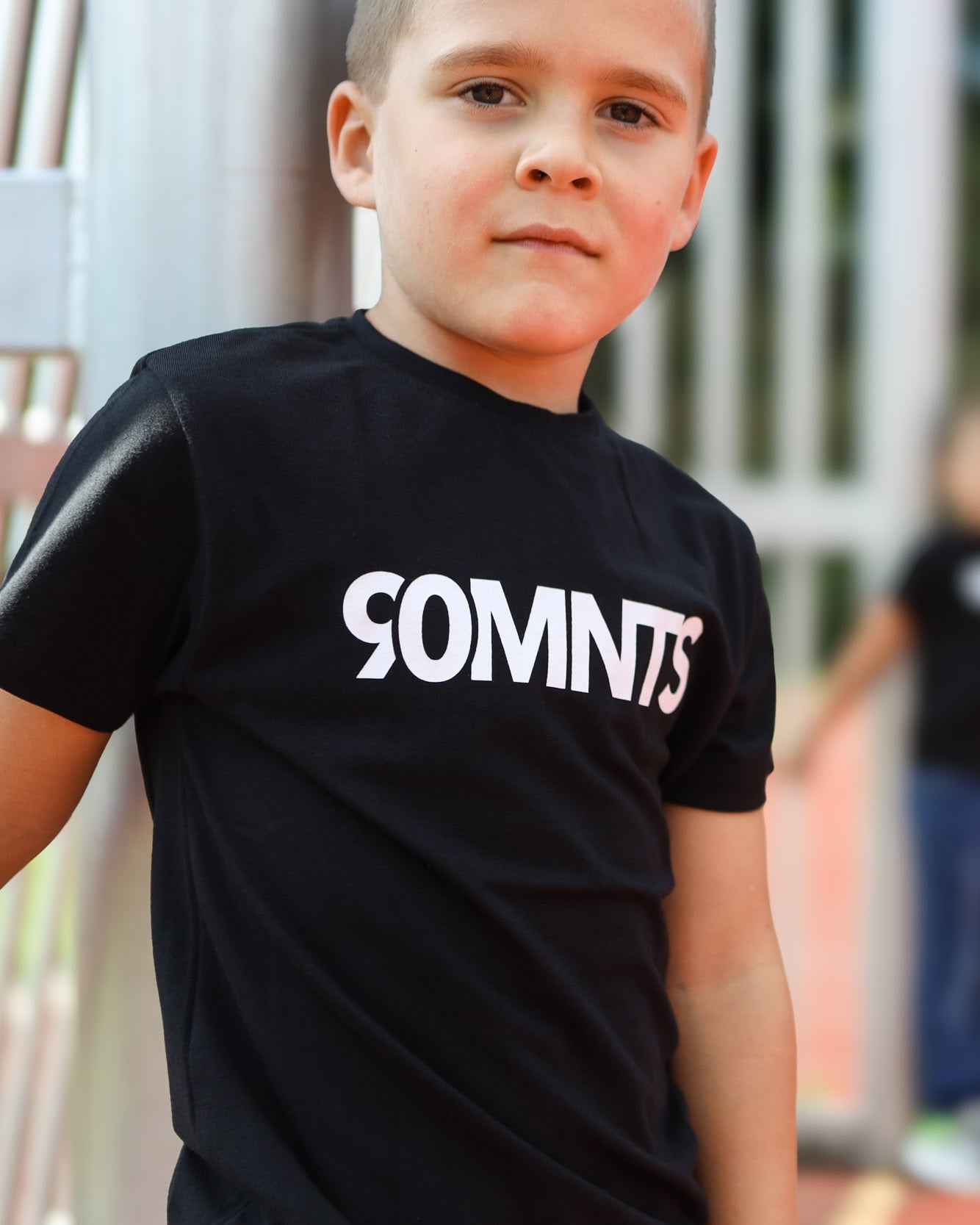 Kind trägt 90 Core T-Shirt in schwarz mit weißem Print