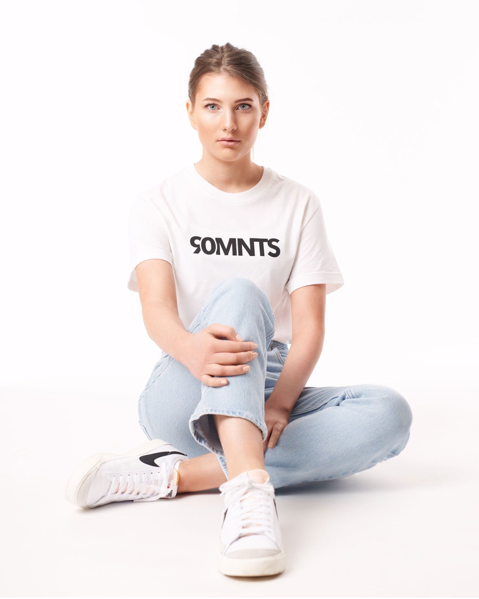 Weibliches Model (sitzend) trägt das 90 Core T-Shirt weiß