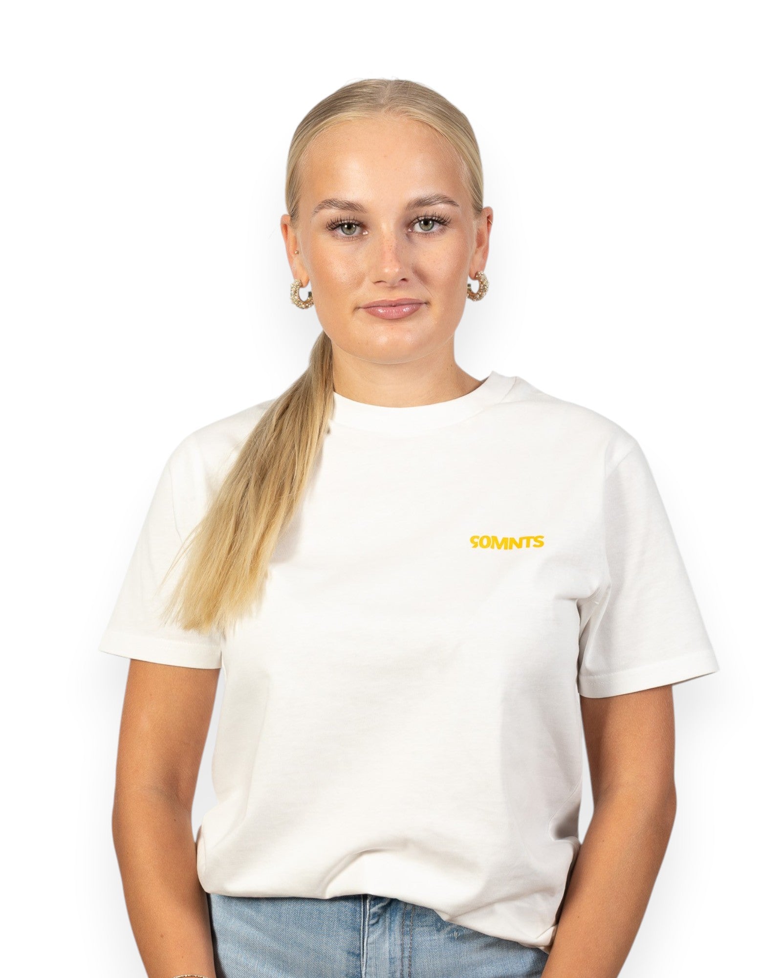 Weibliches Model trägt 90MNTS T-Shirt in weiß mit kleinem Print in orange